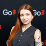 woman looking at the camera, dressed black with bright hair