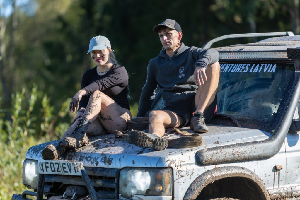 sieviete un vīrietis sēž uz kravas automašīnas
