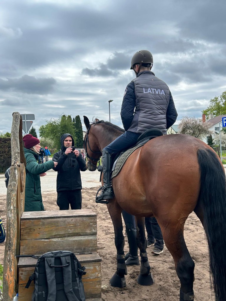 vīrietis uz zirga un filmēšanas grupa
