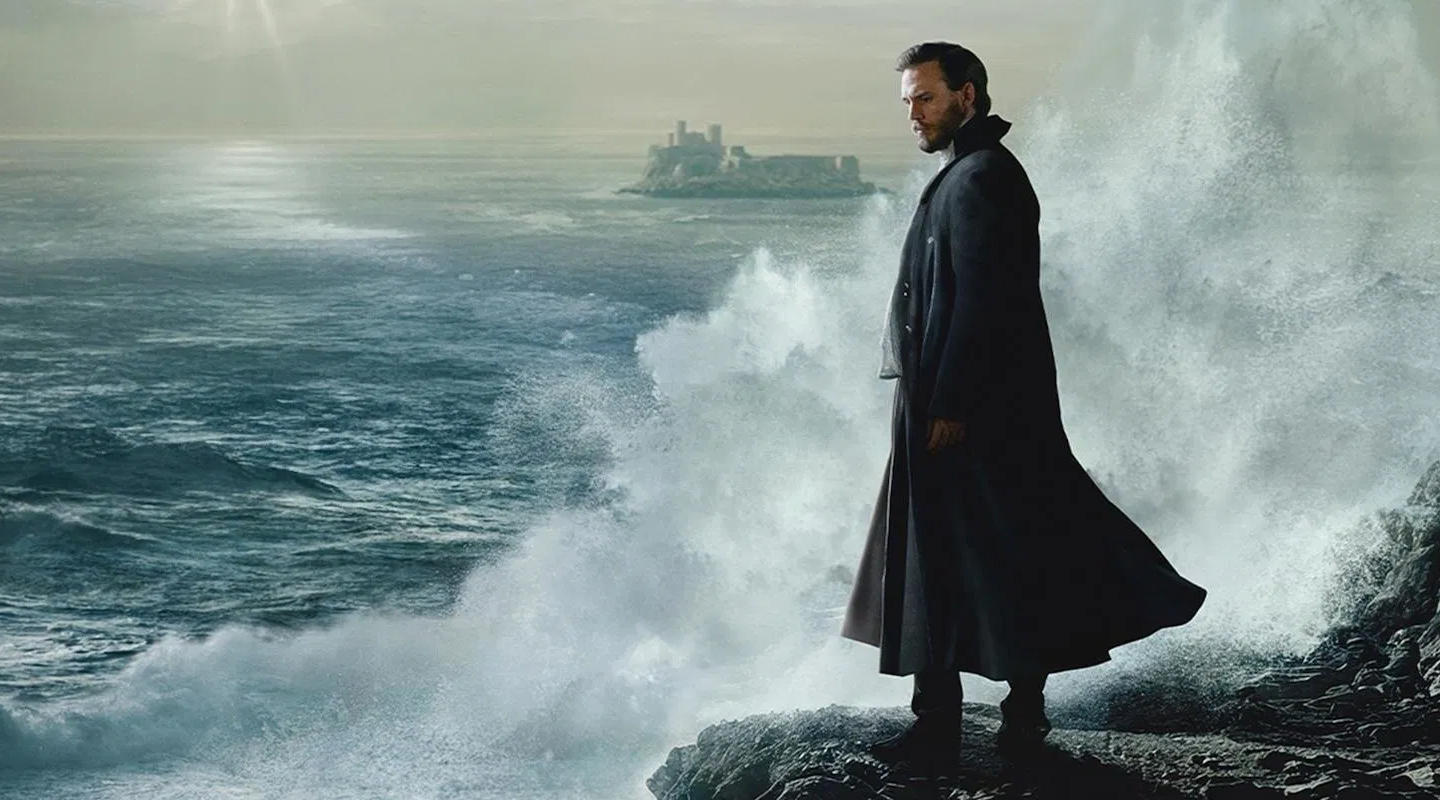 a man dressed black looking down the sea