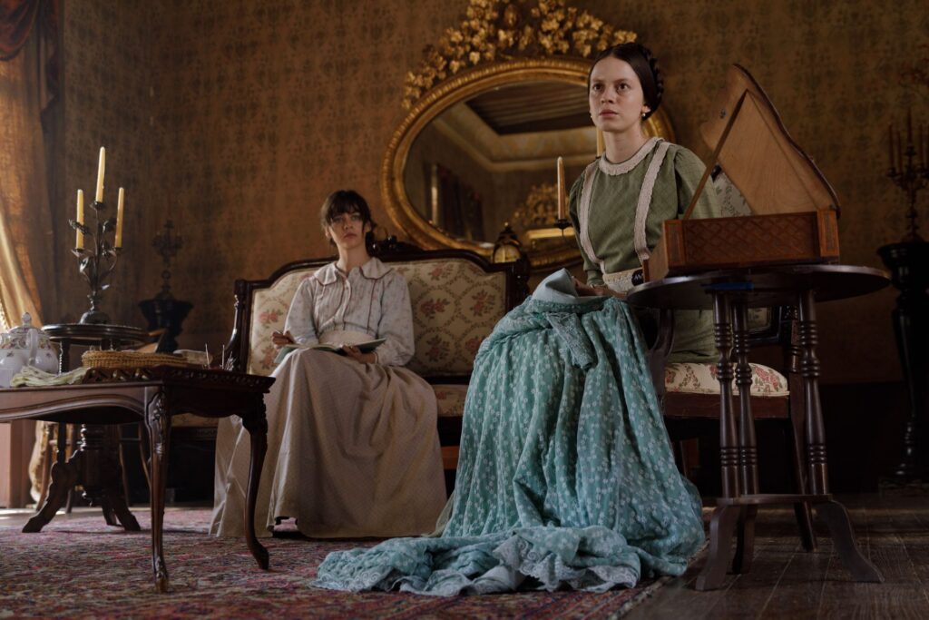 Divas sievietes sēž uz dīvāna viduslaiku vidē