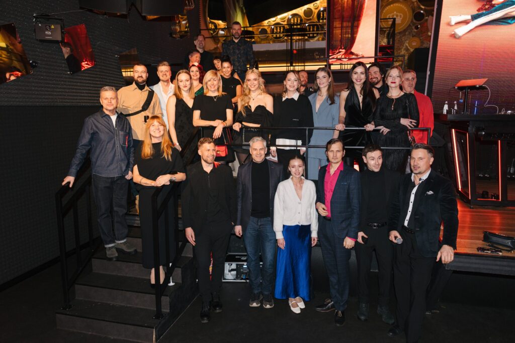 daudzi cilvēki stāv kinoteātra iekārtojumā
