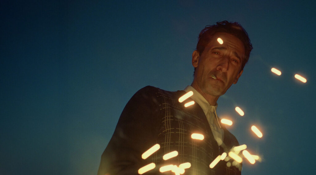 vīrietis skatās uz leju, un gaisma viņu šķērso