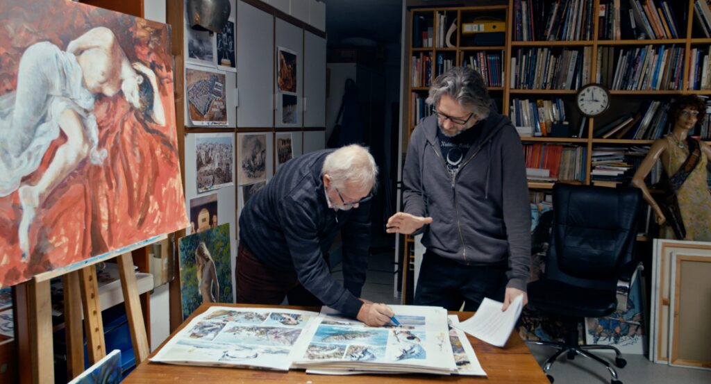 divi vīrieši skatās uz zīmējumiem
