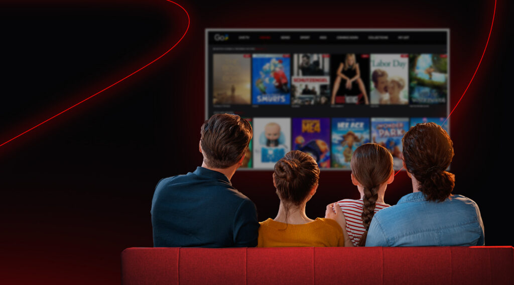 a family sitting on a sofa and watching go3