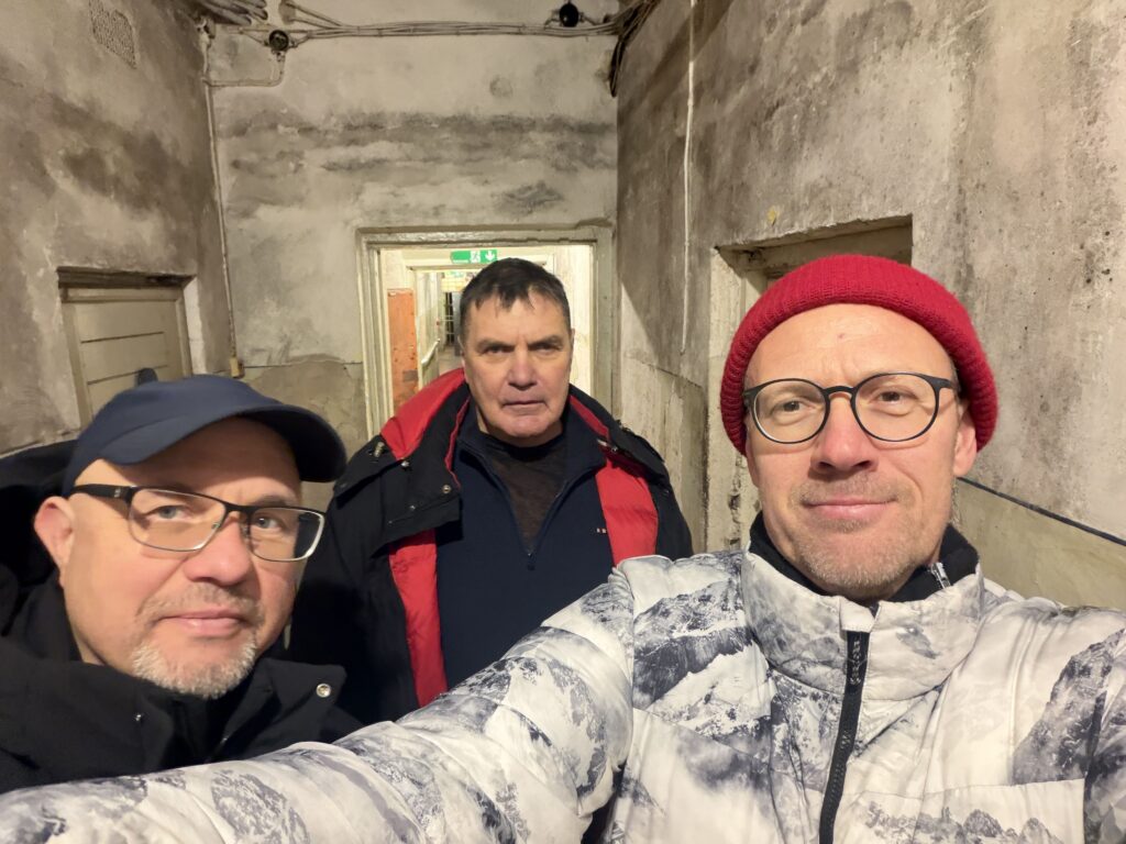 trīs vīrieši uzņem selfiju