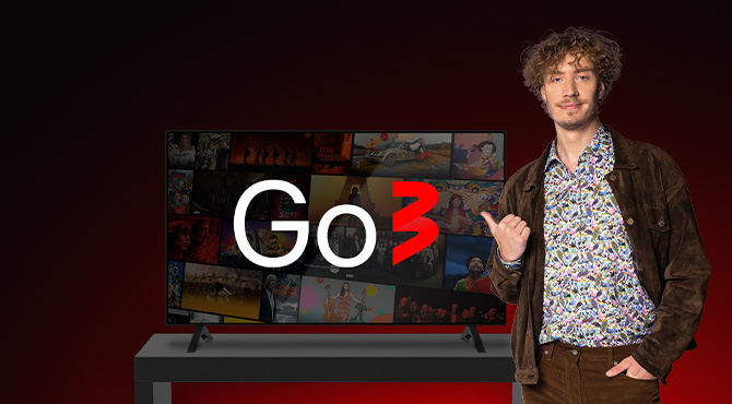 vīrietis stāv blakus go3 televizoram